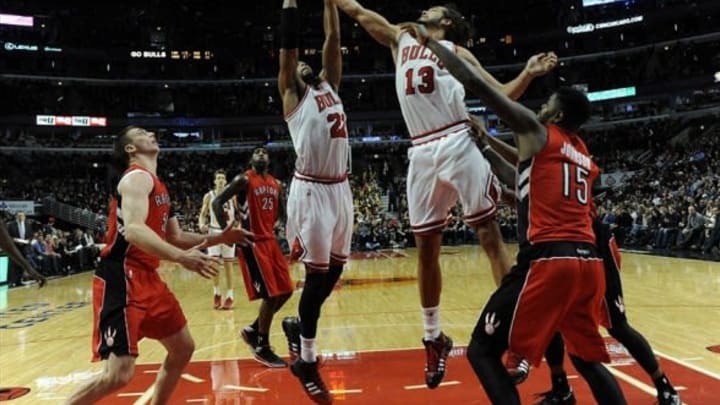 Dec 14, 2013; Chicago, IL, USA; Chicago Bulls power forward Taj Gibson (22) and center Joakim Noah (13) go for the ball in front of Toronto Raptors power forward Amir Johnson (15) during the second half at the United Center. The Toronto Raptors defeated the Chicago Bulls 99-77. Mandatory Credit: David Banks-USA TODAY Sports