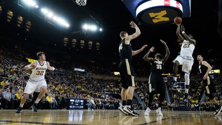 Feb 13, 2016; Ann Arbor, MI, USA; Michigan Wolverines guard Caris LeVert (23) shoots over Purdue Boilermakers guard Rapheal Davis (35) and center Isaac Haas (44) in the first half at Crisler Center. Mandatory Credit: Rick Osentoski-USA TODAY Sports