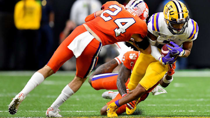 NEW ORLEANS, LOUISIANA - JANUARY 13: Justin Jefferson #2 of the LSU Tigers is tackled by Nolan Turner #24, and K'Von Wallace #12 of the Clemson Tigers during the fourth quarter of the College Football Playoff National Championship game at the Mercedes Benz Superdome on January 13, 2020 in New Orleans, Louisiana. The LSU Tigers topped the Clemson Tigers, 42-25. (Photo by Alika Jenner/Getty Images)