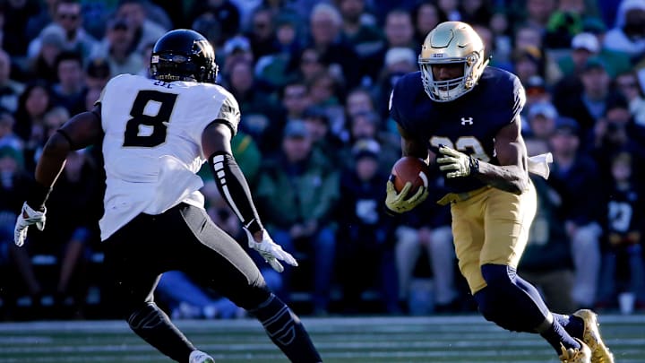 SOUTH BEND, IN – NOVEMBER 14: Josh Adams #33 of the Notre Dame Fighting Irish rushes aainst Marquel Lee #8 of the Wake Forest Demon Deacons during the first quarter at Notre Dame Stadium on November 14, 2015 in South Bend, Indiana. (Photo by Jon Durr/Getty Images)