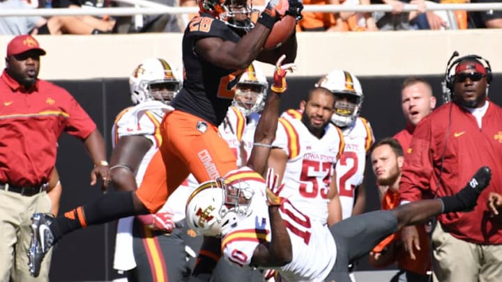 STILLWATER, OK - OCTOBER 8: Wide receiver James Washington #28 of the Oklahoma State Cowboys jumps over defensive back Brian Peavy #10 of the Iowa State Cyclones to catch a pass during the first half of a NCAA football game at Boone Pickens Stadium on October 8, 2016 in Stillwater, Oklahoma. (Photo by J Pat Carter/Getty Images)
