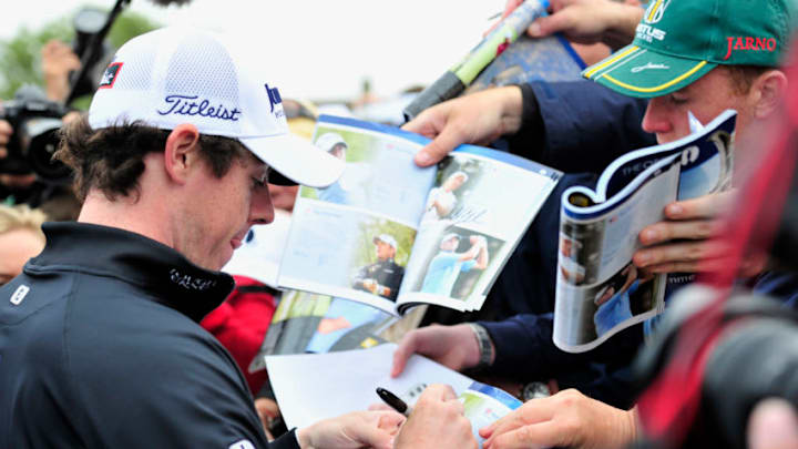 Northern Irish golfer Rory McIlroy (L) signs autographs during the practice rounds ahead of the 140th British Open Golf championship at Royal St George's in Sandwich, Kent, south east England, on July 13, 2011. AFP PHOTO / GLYN KIRK (Photo credit should read GLYN KIRK/AFP via Getty Images)