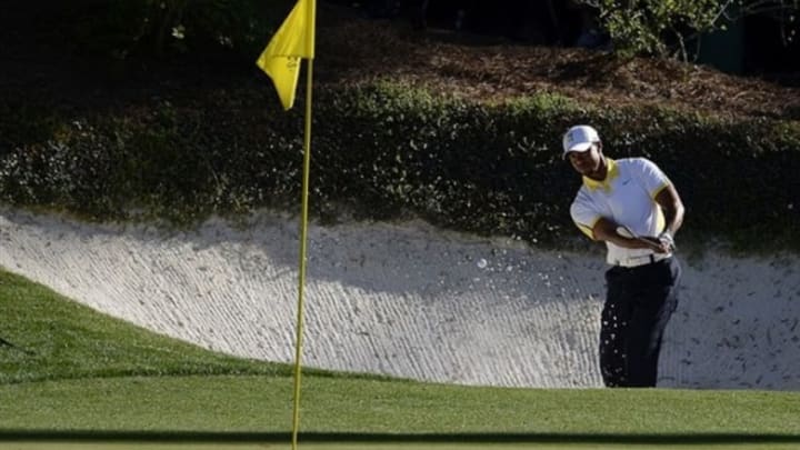 Apr 12, 2013; Augusta, GA, USA; Tiger Woods hits out of a bunker on the 12th hole during the second round of the 2013 The Masters golf tournament at Augusta National Golf Club. Mandatory Credit: Michael Madrid-USA TODAY Sports