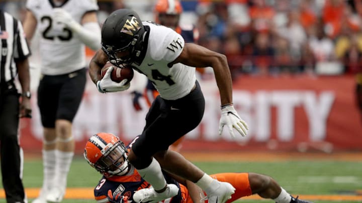 SYRACUSE, NEW YORK - NOVEMBER 30: Donavon Greene #24 of the Wake Forest Demon Deacons runs the ball as Christopher Fredrick #3 of the Syracuse Orange tackles him during the first half of an NCAA football game at the Carrier Dome on November 30, 2019 in Syracuse, New York. (Photo by Bryan M. Bennett/Getty Images)