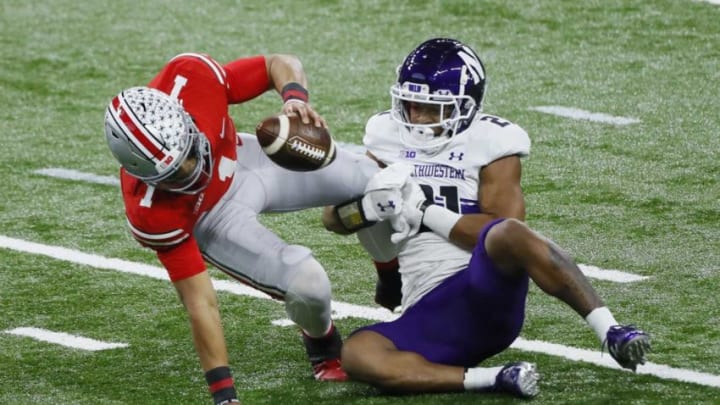 Northwestern Wildcats defensive back Cameron Mitchell (21) sacks Ohio State Buckeyes quarterback Justin Fields (1) during the first quarter of the Big Ten Championship football game at Lucas Oil Stadium in Indianapolis on Saturday, Dec. 19, 2020.Big Ten Championship Ohio State Northwestern
