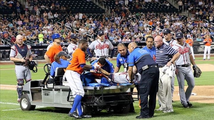 Jul 24, 2013; New York, NY, USA; Atlanta Braves starting pitcher Tim Hudson (15) is taken off the field on a cart after being injured in collision at first base with New York Mets left fielder Eric Young Jr. (not pictured) during the eighth inning at Citi Field. Mandatory Credit: Anthony Gruppuso-USA TODAY Sports