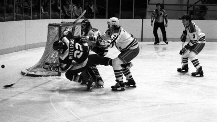 New York Rangers’ goalie Ed Mio (c) and defense men Tom Laidlaw (R) take Tiger Williams (L) of the Vancouver Canucks out of the play 1/7. The Rangers handed the Canucks their ninth straight road loss by beating them 4-1 at Madison Square Garden.