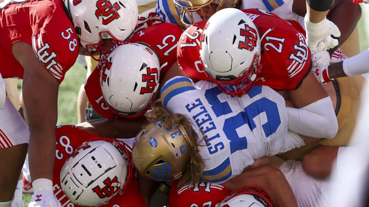 Sep 23, 2023; Salt Lake City, Utah, USA; UCLA Bruins running back Carson Steele (33) is tackled by five Utah Utes in the second half at Rice-Eccles Stadium. Mandatory Credit: Rob Gray-USA TODAY Sports