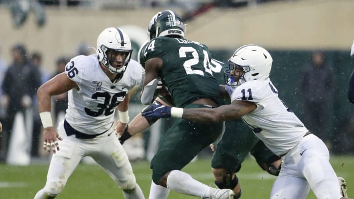 EAST LANSING, MI – OCTOBER 26: Running back Elijah Collins #24 of the Michigan State Spartans is tackled by linebacker Micah Parsons #11 of the Penn State Nittany Lions with linebacker Jan Johnson #36 during the first half at Spartan Stadium on October 26, 2019 in East Lansing, Michigan. Penn State defeated Michigan State 28-7. (Photo by Duane Burleson/Getty Images)