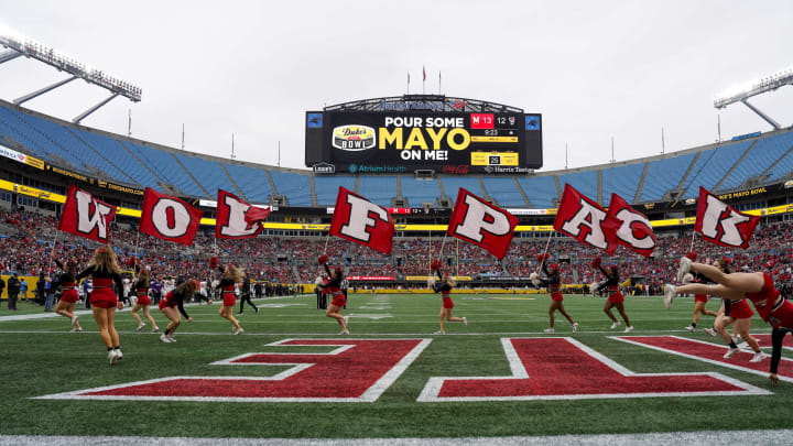 Dec 30, 2022; Charlotte, NC, USA; North Carolina State Wolfpack cheerleaders run across the end zone with team flags during the second half against the Maryland Terrapins in the 2022 Duke’s Mayo Bowl at Bank of America Stadium. Mandatory Credit: Jim Dedmon-USA TODAY Sports