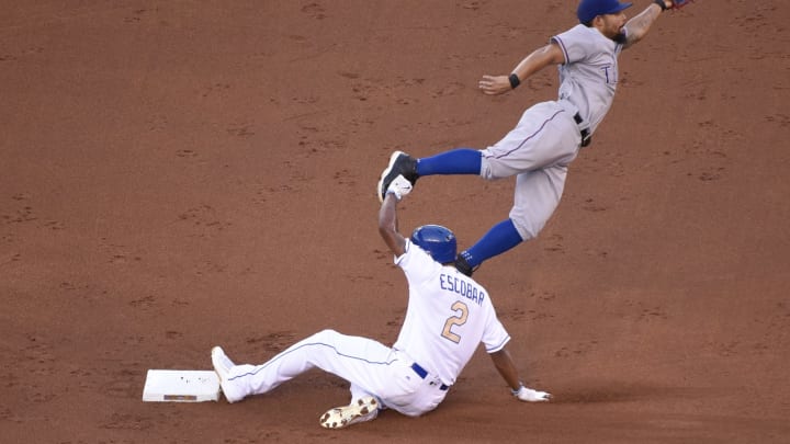 KANSAS CITY, MO – JULY 22: Alcides Escobar #2 of the Kansas City Royals slides into second for a steal as Rougned Odor #12 of the Texas Rangers can’t catch the throw from Bobby Wilson #6 in the first inning at Kauffman Stadium on July 22, 2016 in Kansas City, Missouri. (Photo by Ed Zurga/Getty Images)