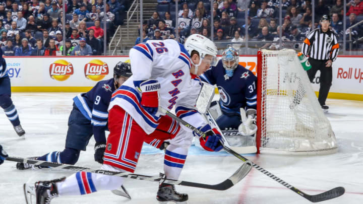 WINNIPEG, MB - FEBRUARY 12: Goaltender Connor Hellebuyck #37 of the Winnipeg Jets guards the net as Jimmy Vesey #26 of the New York Rangers plays the puck behind the goal line during first period action at the Bell MTS Place on February 12, 2019 in Winnipeg, Manitoba, Canada. (Photo by Jonathan Kozub/NHLI via Getty Images)