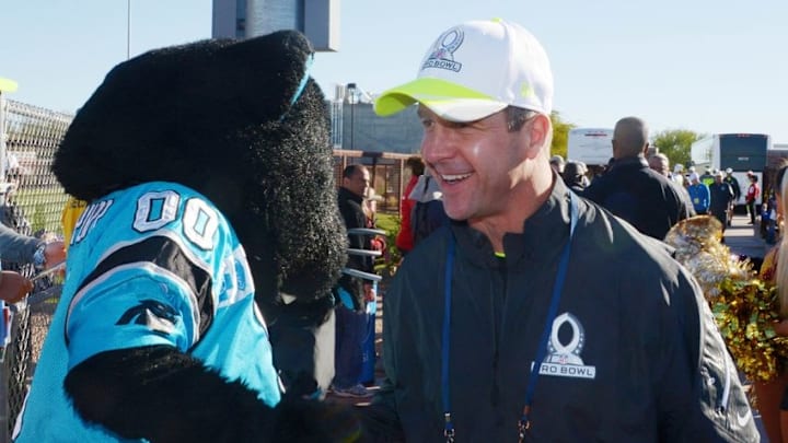 Jan 24, 2015; Scottsdale, AZ, USA; Baltimore Ravens coach John Harbaugh (right) is greeted by Carolina Panthers mascot Sir Purr at Team Carter practice for the 2015 Pro Bowl at Scottsdale Community College. Mandatory Credit: Kirby Lee-USA TODAY Sports