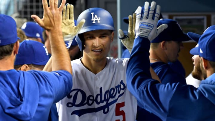 LOS ANGELES, CA - APRIL 12: Corey Seager #5 of the Los Angeles Dodgers is greeted in the dugout after hitting a solo home run in the first inning of the game against the Milwaukee Brewers at Dodger Stadium on April 12, 2019 in Los Angeles, California. (Photo by Jayne Kamin-Oncea/Getty Images)