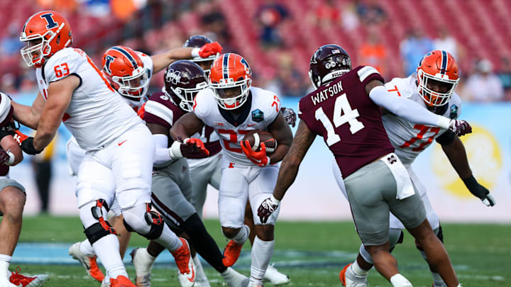 Jan 2, 2023; Tampa, FL, USA; Illinois Fighting Illini running back Reggie Love III (23) runs with the ball against the Mississippi State Bulldogs in the first quarter during the 2023 ReliaQuest Bowl at Raymond James Stadium. Mandatory Credit: Nathan Ray Seebeck-USA TODAY Sports