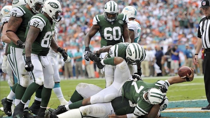 Dec 29, 2013; Miami Gardens, FL, USA; New York Jets quarterback Geno Smith (7) scores a touchdown in the final seconds of the first half against the Miami Dolphins at Sun Life Stadium. Mandatory Credit: Brad Barr-USA TODAY Sportsnew