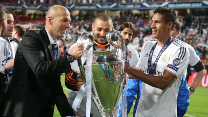 LISBON, PORTUGAL - MAY 24: Assistant-coach of Real Madrid Zinedine Zidane, Karim Benzema and Raphael Varane of Real Madrid hold the trophy after the UEFA Champions League final between Real Madrid and Atletico de Madrid at Estadio da Luz stadium on May 24, 2014 in Lisbon, Portugal. (Photo by Jean Catuffe/Getty Images)