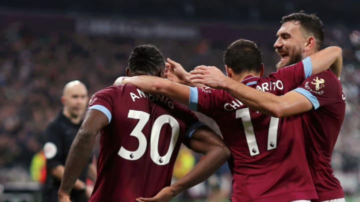 LONDON, ENGLAND - FEBRUARY 04: Michail Antonio of West Ham United holds his back while celebrates with team mates Javier Hernandez and Robert Snodgrass after scoring their team's first goal during the Premier League match between West Ham United and Liverpool FC at London Stadium on February 04, 2019 in London, United Kingdom. (Photo by Richard Heathcote/Getty Images)