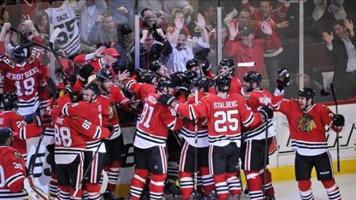 May 29, 2013; Chicago, IL, USA; Chicago Blackhawks defenseman Brent Seabrook (7) is mobbed by his teammates after scoring the game-winning goal against the Detroit Red Wings in overtime in game seven of the second round of the 2013 Stanley Cup Playoffs at the United Center. The Blackhawks won 2-1 to win the series four games to three. Mandatory Credit: Rob Grabowski-USA TODAY Sports