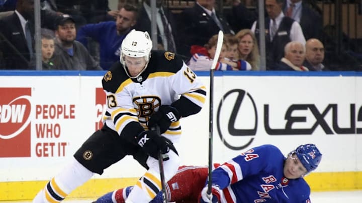 NEW YORK, NEW YORK - OCTOBER 27: Charlie Coyle #13 of the Boston Bruins moves the puck past Kaapo Kakko #24 of the New York Rangers during the first period at Madison Square Garden on October 27, 2019 in New York City. (Photo by Bruce Bennett/Getty Images)