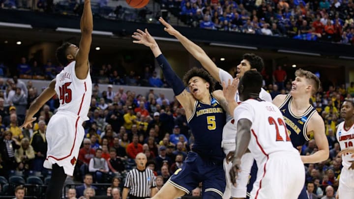 INDIANAPOLIS, IN - MARCH 19: D.J. Wilson #5 of the Michigan Wolverines attempts a shot against Donovan Mitchell #45, Anas Mahmoud #14 and Deng Adel #22 of the Louisville Cardinals in the first half during the second round of the 2017 NCAA Men's Basketball Tournament at the Bankers Life Fieldhouse on March 19, 2017 in Indianapolis, Indiana. (Photo by Joe Robbins/Getty Images)
