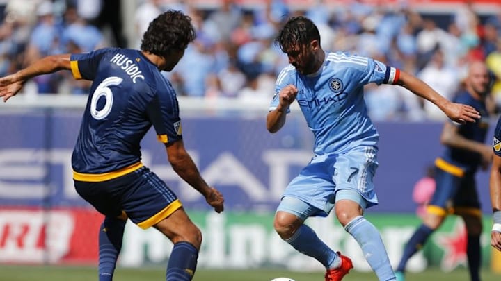 Aug 20, 2016; New York, NY, USA; New York City FC forward David Villa (7) dribbles the ball against Los Angeles Galaxy midfielder Baggio Husidic (6) during first half at Yankee Stadium. Mandatory Credit: Noah K. Murray-USA TODAY Sports