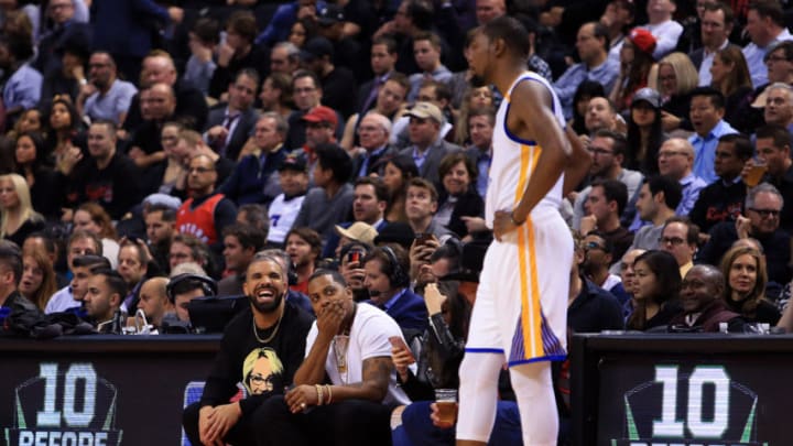 TORONTO, ON - NOVEMBER 16: Drake laughs with Kevin Durant #35 of the Golden State Warriors in the second half of an NBA game against the Toronto Raptors at Air Canada Centre on November 16, 2016 in Toronto, Canada. NOTE TO USER: User expressly acknowledges and agrees that, by downloading and or using this photograph, User is consenting to the terms and conditions of the Getty Images License Agreement. (Photo by Vaughn Ridley/Getty Images)