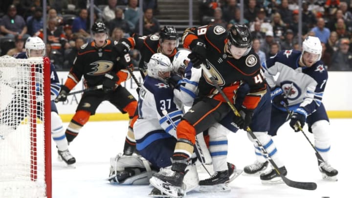 ANAHEIM, CALIFORNIA - OCTOBER 29: Connor Hellebuyck #37 of the Winnipeg Jets defends against Max Jones #49 of the Anaheim Ducks during the first period of a game at Honda Center on October 29, 2019 in Anaheim, California. (Photo by Sean M. Haffey/Getty Images)