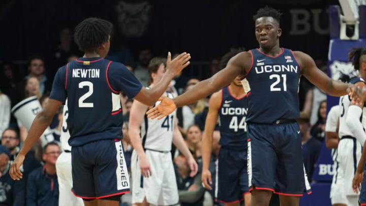 Dec 17, 2022; Indianapolis, Indiana, USA; Connecticut Huskies forward Adama Sanogo (21) high-fives guard Tristen Newton (2) after a made basket and a foul against the Butler Bulldogs during the first half at Hinkle Fieldhouse. Mandatory Credit: Robert Goddin-USA TODAY Sports