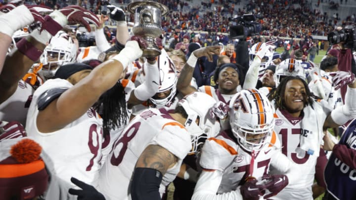 Nov 25, 2023; Charlottesville, Virginia, USA; Virginia Tech Hokies players celebrate with the Commonwealth Cup after their game against the Virginia Cavaliers at Scott Stadium. Mandatory Credit: Geoff Burke-USA TODAY Sports