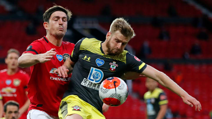 Southampton's Scottish midfielder Stuart Armstrong (R) vies with Manchester United's English defender Harry Maguire (L) during the English Premier League football match between Manchester United and Southampton at Old Trafford in Manchester, north-west England, on July 13, 2020. (Photo by Clive Brunskill / POOL / AFP) / RESTRICTED TO EDITORIAL USE. No use with unauthorized audio, video, data, fixture lists, club/league logos or 'live' services. Online in-match use limited to 120 images. An additional 40 images may be used in extra time. No video emulation. Social media in-match use limited to 120 images. An additional 40 images may be used in extra time. No use in betting publications, games or single club/league/player publications. / (Photo by CLIVE BRUNSKILL/POOL/AFP via Getty Images)