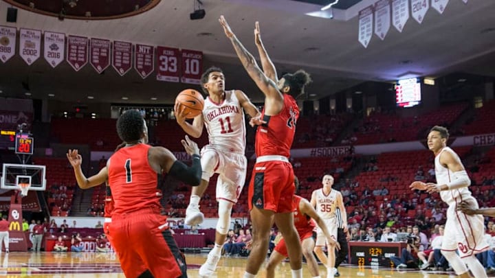 NORMAN, OK - NOVEMBER 15: Trae Young (11) of the Oklahoma Sooners drives to the basket against Trey Moses (24) of the Ball State Cardinals during the Oklahoma Sooners against the Ball State Cardinals at the Lloyd Noble Center in Norman, Ok. (Photo by Richard Rowe/Icon Sportswire via Getty Images)