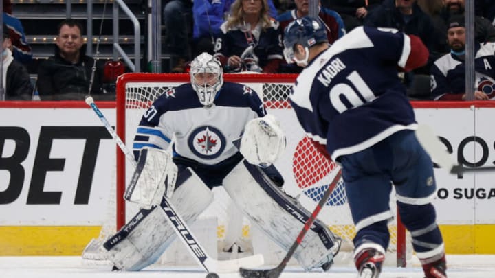 Feb 25, 2022; Denver, Colorado, USA; Colorado Avalanche center Nazem Kadri (91) takes a shot against Winnipeg Jets goaltender Connor Hellebuyck (37) in the third period at Ball Arena. Mandatory Credit: Isaiah J. Downing-USA TODAY Sports