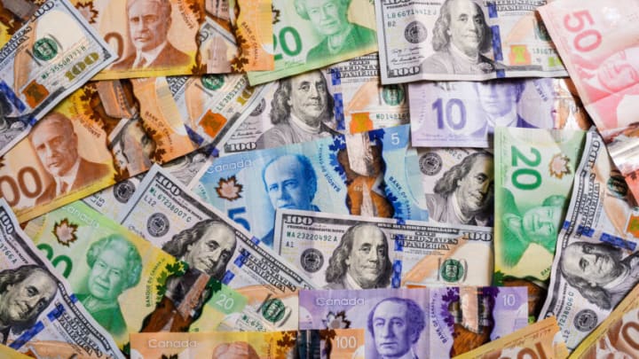 POLAND - 2020/04/04: In this photo illustration US Dollar and Canadian Dollar banknotes. (Photo Illustration by Cezary Kowalski/SOPA Images/LightRocket via Getty Images)