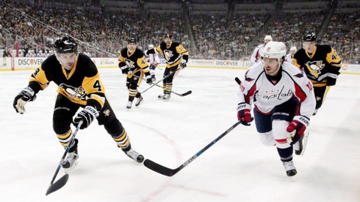 Mar 20, 2016; Pittsburgh, PA, USA; Pittsburgh Penguins defenseman Justin Schultz (4) and Washington Capitals center Mike Richards (10) chase the puck during the first period at the CONSOL Energy Center. Mandatory Credit: Charles LeClaire-USA TODAY Sports