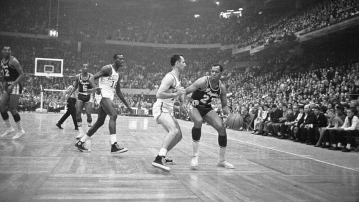 (Original Caption) Elgin Baylor, (right), of the Los Angeles Lakers, tries to maneuver the ball around Bob Cousy of the Boston Celtics during second half quarter action. Los Angeles won the fifth game of the NBA Championship 126-119.