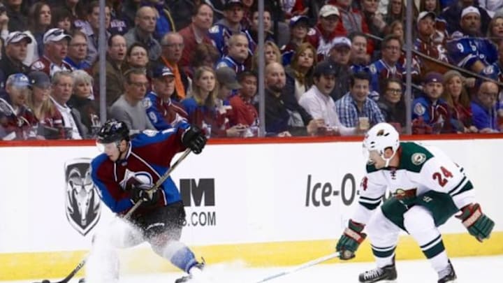 Oct 11, 2014; Denver, CO, USA; Colorado Avalanche defenseman Tyson Barrie (4) controls the puck against Minnesota Wild left wing Matt Cooke (24) in the first period at the Pepsi Center. Mandatory Credit: Isaiah J. Downing-USA TODAY Sports