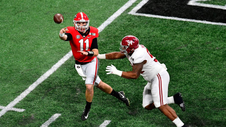 ATLANTA, GA – JANUARY 08: Jake Fromm #11 of the Georgia Bulldogs throws a pass under pressure from Da’Ron Payne #94 of the Alabama Crimson Tide during the first quarter in the CFP National Championship presented by AT&T at Mercedes-Benz Stadium on January 8, 2018 in Atlanta, Georgia. (Photo by Scott Cunningham/Getty Images)