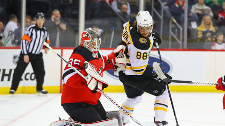 NEWARK, NJ - MARCH 21: New Jersey Devils goaltender Cory Schneider (35) makes a save as Boston Bruins right wing David Pastrnak (88) sets up in front of him during the first period of the National Hockey League game between the New Jersey Devils and the Boston Bruins on March 21, 2019 at the Prudential Center in Newark, NJ. (Photo by Rich Graessle/Icon Sportswire via Getty Images)