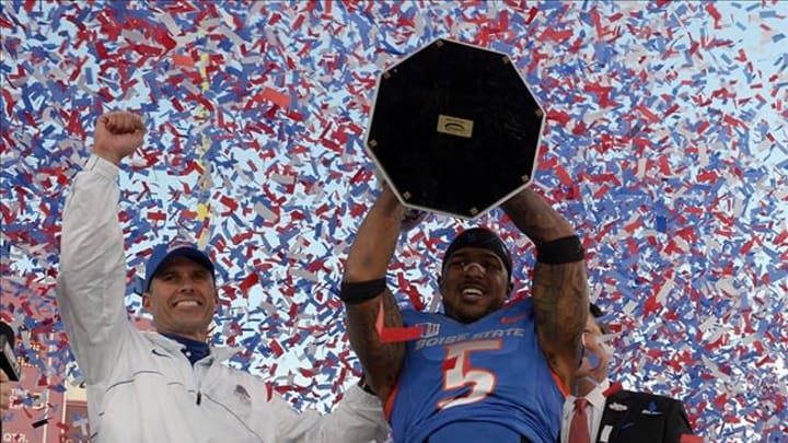 Dec 22, 2012; Las Vegas, NV, USA; Boise State Broncos coach Chris Petersen (left) and cornerback Jamar Taylor (5) hoist the 2012 Maaco Bowl trophy after the game against the Washington Huskies at Sam Boyd Stadium. Boise State defeated Washington 28-26. Mandatory Credit: Kirby Lee/Image of Sport-USA TODAY Sports