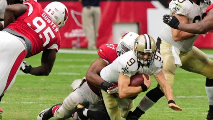 Sep 13, 2015; Glendale, AZ, USA; New Orleans Saints quarterback Drew Brees (9) is sacked by Arizona Cardinals outside linebacker Alex Okafor (57) during the second half at University of Phoenix Stadium. Mandatory Credit: Matt Kartozian-USA TODAY Sports