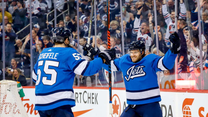 WINNIPEG, MB – MARCH 16: Mark Scheifele #55 and Ben Chiarot #7 of the Winnipeg Jets celebrate a first period goal against the Calgary Flames at the Bell MTS Place on March 16, 2019 in Winnipeg, Manitoba, Canada. (Photo by Darcy Finley/NHLI via Getty Images)