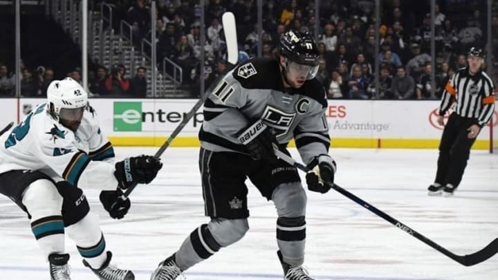 Dec 31, 2016; Los Angeles, CA, USA; Los Angeles Kings center Anze Kopitar (11) and San Jose Sharks right wing Joel Ward (42) reach for the puck in the second period during a NHL hockey match at Staples Center. Mandatory Credit: Kirby Lee-USA TODAY Sports