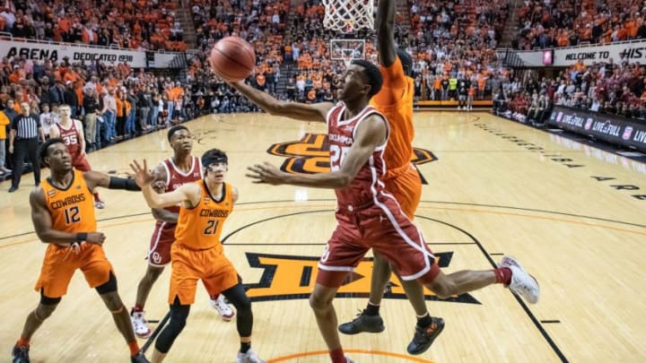 Feb 22, 2020; Stillwater, Oklahoma, USA; Oklahoma Sooners guard Jamal Bieniemy (24) shoots the ball while defended by Oklahoma State Cowboys forward Yor Anei (14) during the first half at Gallagher-Iba Arena. Mandatory Credit: Rob Ferguson-USA TODAY Sports