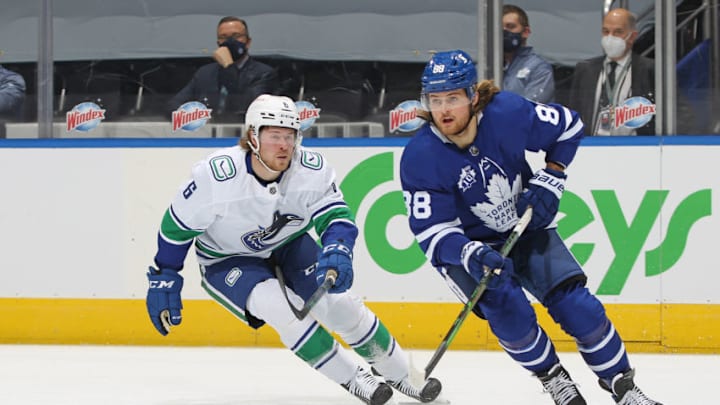 TORONTO, ON - FEBRUARY 4: William Nylander #88 of the Toronto Maple Leafs grabs a pass in front of Brock Boeser #6 of the Vancouver Canucks skates against the Toronto Maple Leafs during an NHL game at Scotiabank Arena on February 4, 2021 in Toronto, Ontario, Canada. (Photo by Claus Andersen/Getty Images)