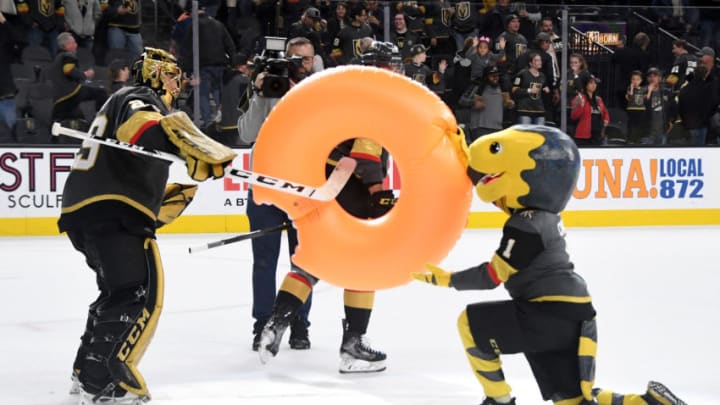 LAS VEGAS, NEVADA - FEBRUARY 26: Marc-Andre Fleury #29 of the Vegas Golden Knights takes an inflatable doughnut, signifying a shutout win, from the Golden Knights mascot Chance the Golden Gila Monster after the team's 3-0 victory over the Edmonton Oilers at T-Mobile Arena on February 26, 2020 in Las Vegas, Nevada. Fleury recorded his 61st career shutout tying Turk Broda for 17th all-time. (Photo by Ethan Miller/Getty Images)