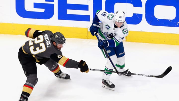 EDMONTON, ALBERTA - AUGUST 23: Elias Pettersson #40 of the Vancouver Canucks moves the puck ahead of Alec Martinez #23 of the Vegas Golden Knights during the first period in Game One of the Western Conference Second Round during the 2020 NHL Stanley Cup Playoffs at Rogers Place on August 23, 2020 in Edmonton, Alberta, Canada. (Photo by Jeff Vinnick/Getty Images)