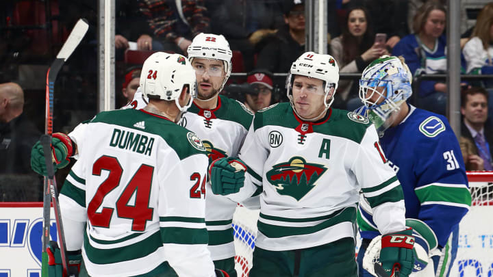 VANCOUVER, BC - DECEMBER 4: Anders Nilsson #31 of the Vancouver Canucks looks on as Zach Parise #11 of the Minnesota Wild is congratulated by teammates Matt Dumba #24 and Nino Niederreiter #22 after scoring during their NHL game at Rogers Arena December 4, 2018 in Vancouver, British Columbia, Canada. (Photo by Jeff Vinnick/NHLI via Getty Images)