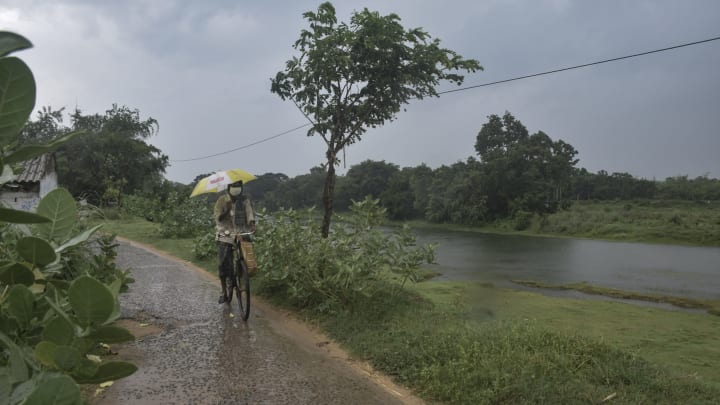 HOOGLY, WEST BENGAL, INDIA – 2021/05/25: A man seen cycling in rain before the landfall of ‘Yaas’ cyclone.Cyclone ‘Yaas’ will probably make landfall amid Balasore and Digha Coastal areas on May 26, Wednesday Morning. As a very severe cyclonic storm, it may cause heavy rainfall in coastal districts of West Bengal and north Odisha. (Photo by Tamal Shee/SOPA Images/LightRocket via Getty Images)