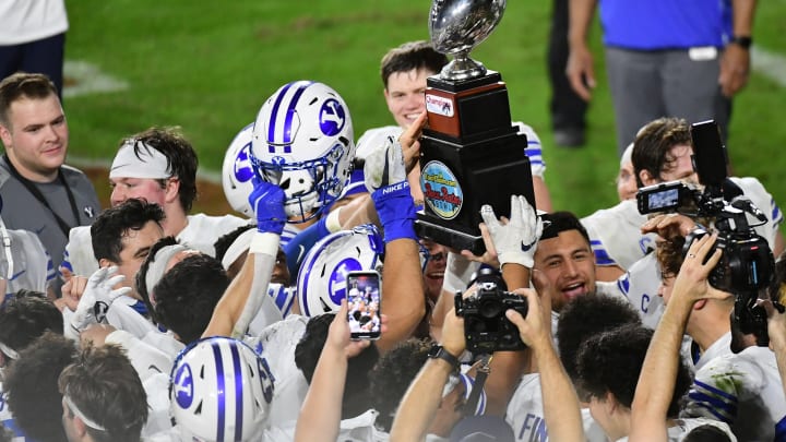 Dec 22, 2020; Boca Raton, Florida, USA; Brigham Young Cougars players celebrate with the trophy after defeating the UCF Knights at FAU Stadium. Mandatory Credit: Jasen Vinlove-USA TODAY Sports